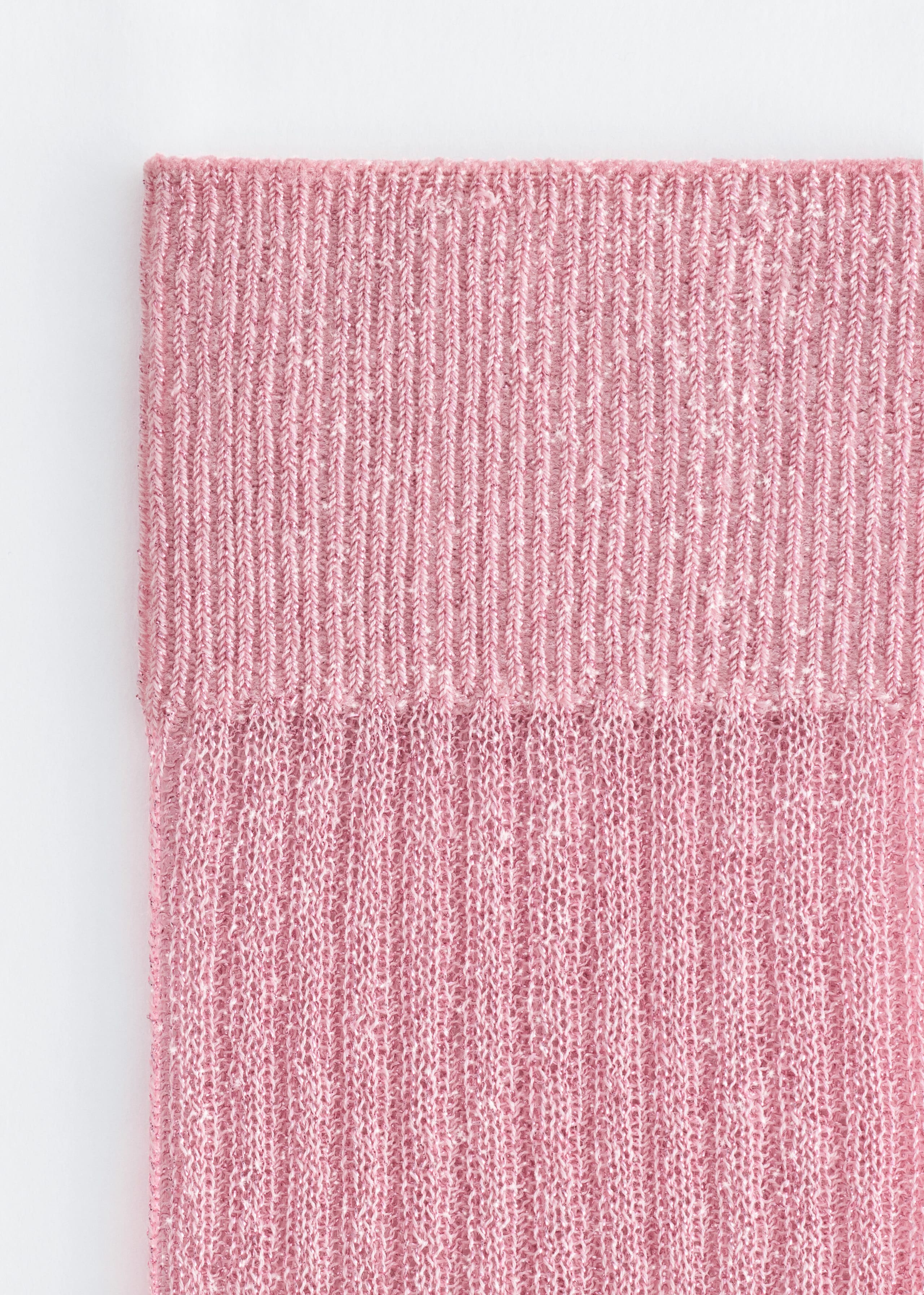 A close-up front view of a pink knit product shows a tightly ribbed elasticised cuff transitioning into a semi-sheer, textured ribbed body.