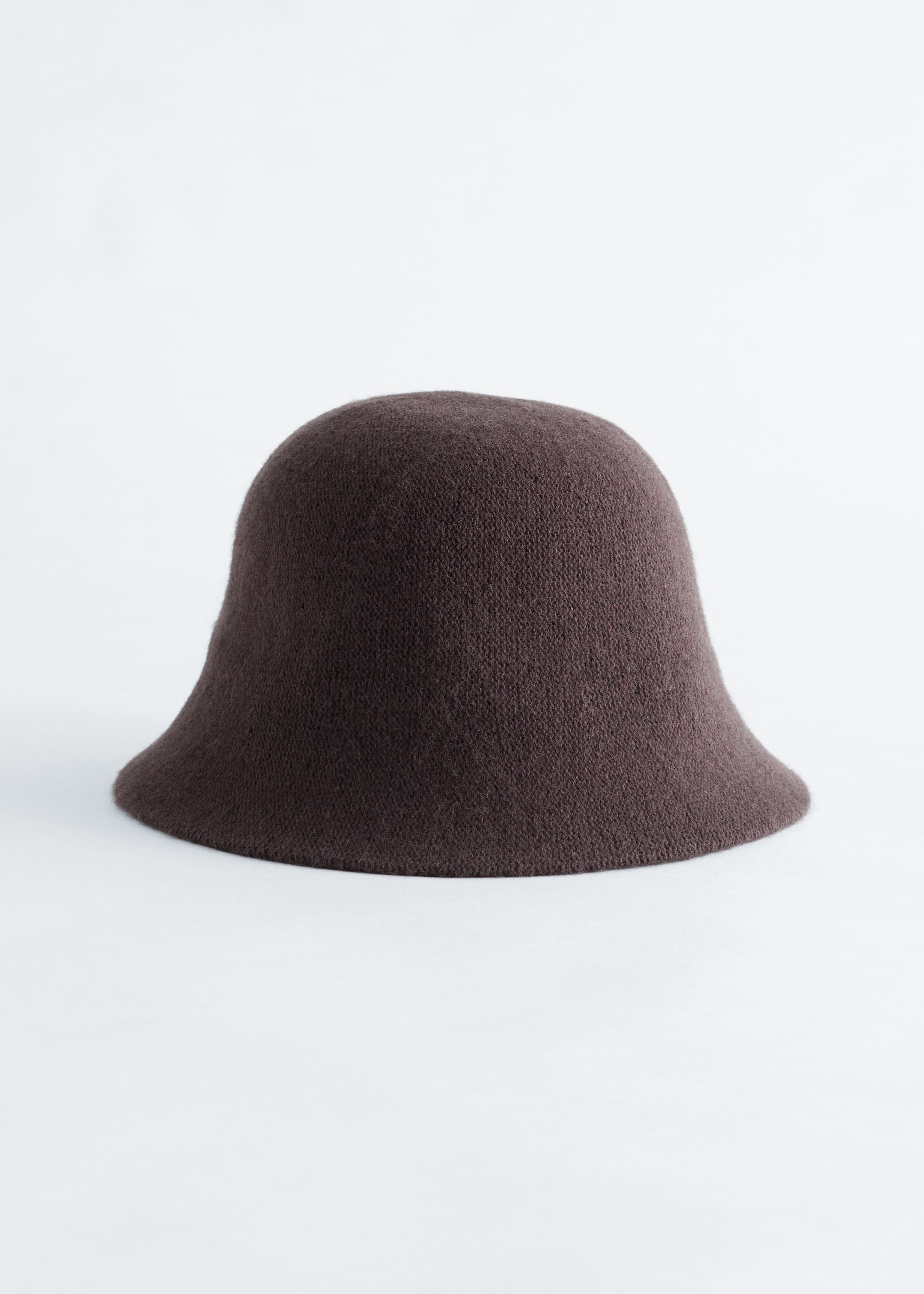 View larger image: A dark brown, moulded bucket hat, knitted from a wool blend, is shown from the front, displaying a rounded crown and a slanted brim.