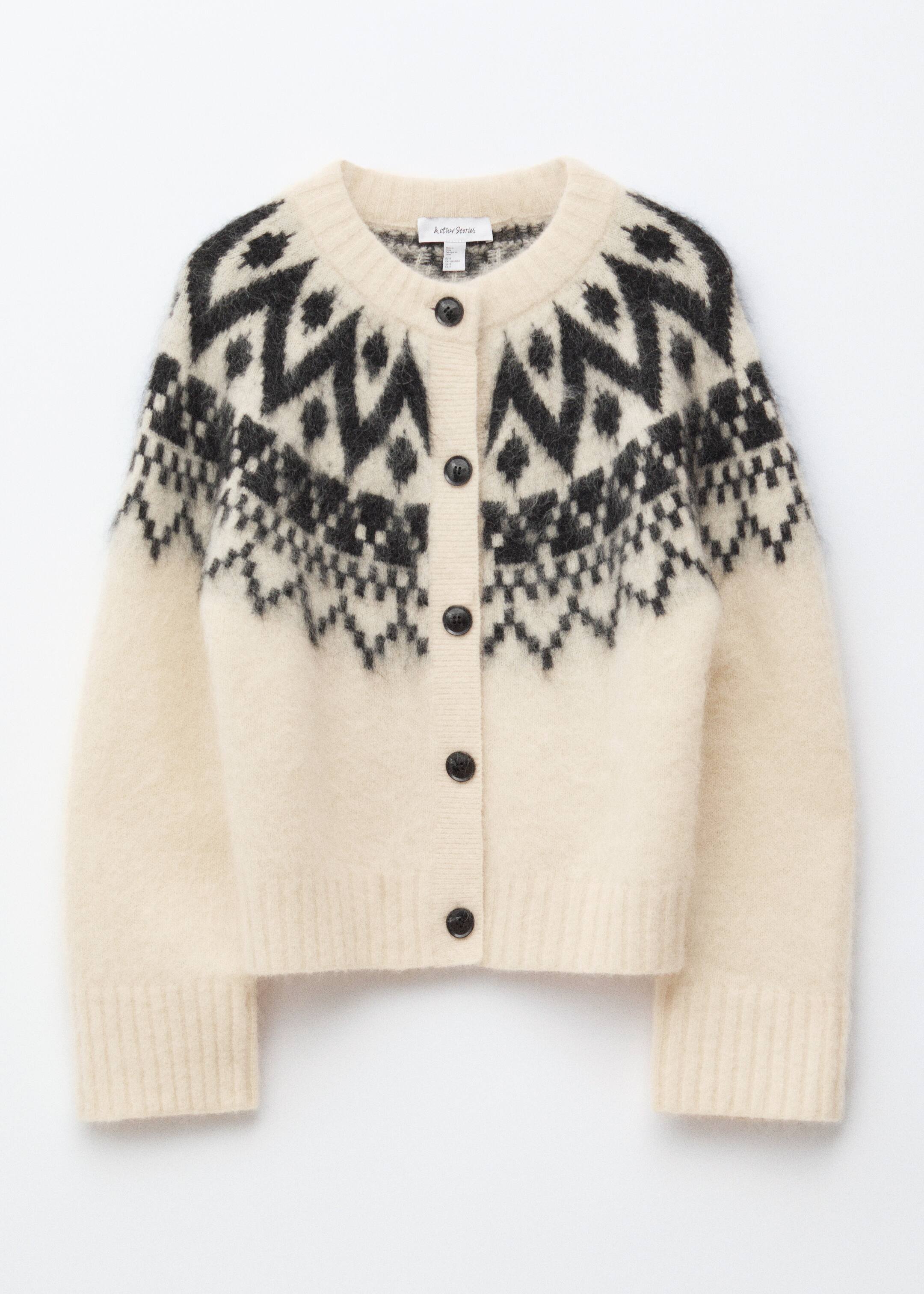 Größeres Bild anzeigen: Eine cremefarbene Strickjacke präsentiert ihre FRONT, die eine flauschige Textur und ein kontrastierendes schwarzes Jacquard-Muster über der Brust und den Schultern aufweist. Sie ist mit einem Rundhalsausschnitt, einer kastigen Silhouette, gerippten Bündchen und Saum sowie schwarzen Knöpfen an der Vorderseite gestaltet.