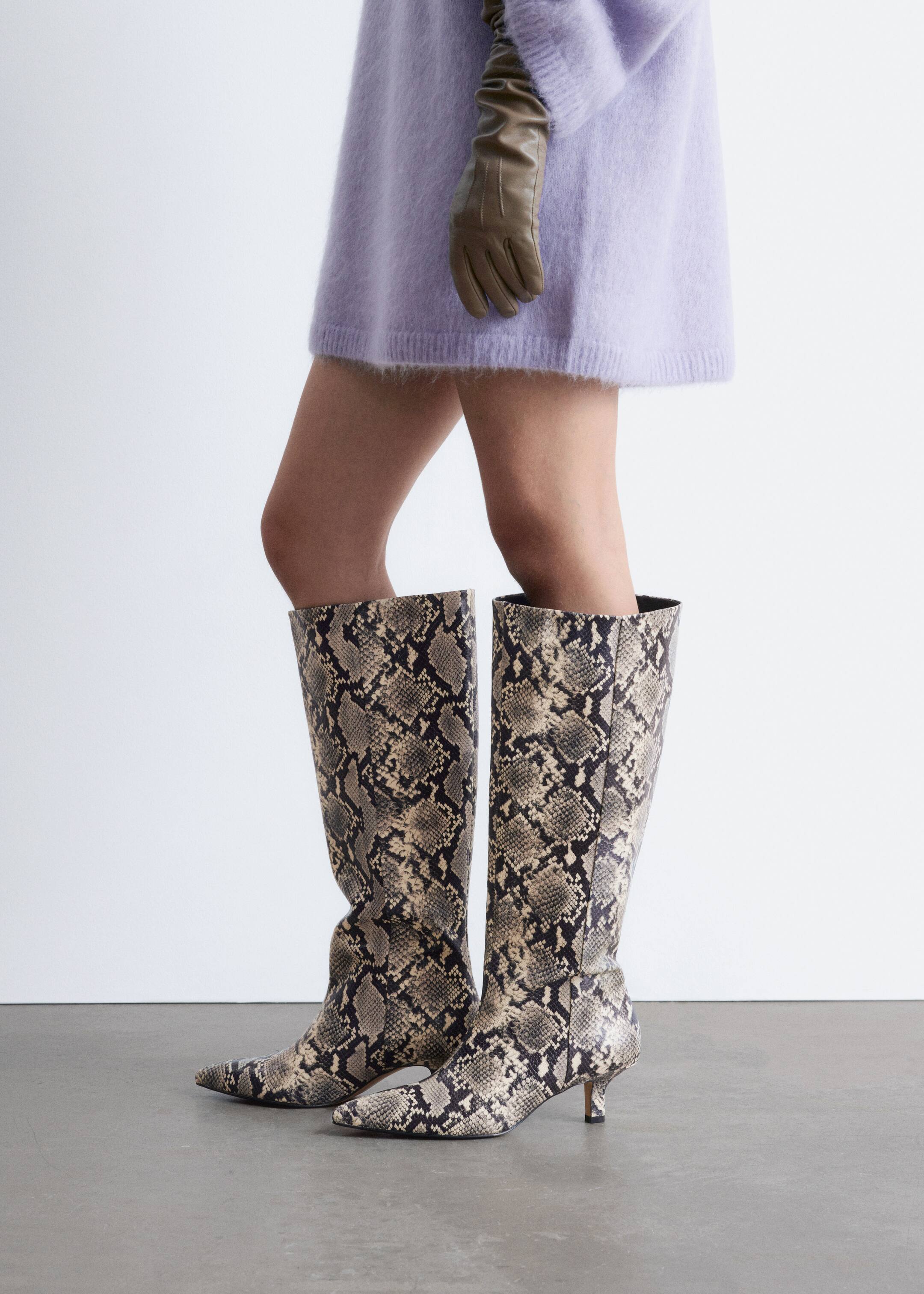 Grösseres Bild ansehen: Kniehohe Stiefel zeigen ein Schlangenhautmuster in Beige-, Braun- und Schwarztönen. Sie sind mit spitzen Zehen und Kittenheels gestaltet, und die Schäfte reichen bis zu den Knien mit einer leicht schlampigen Passform.