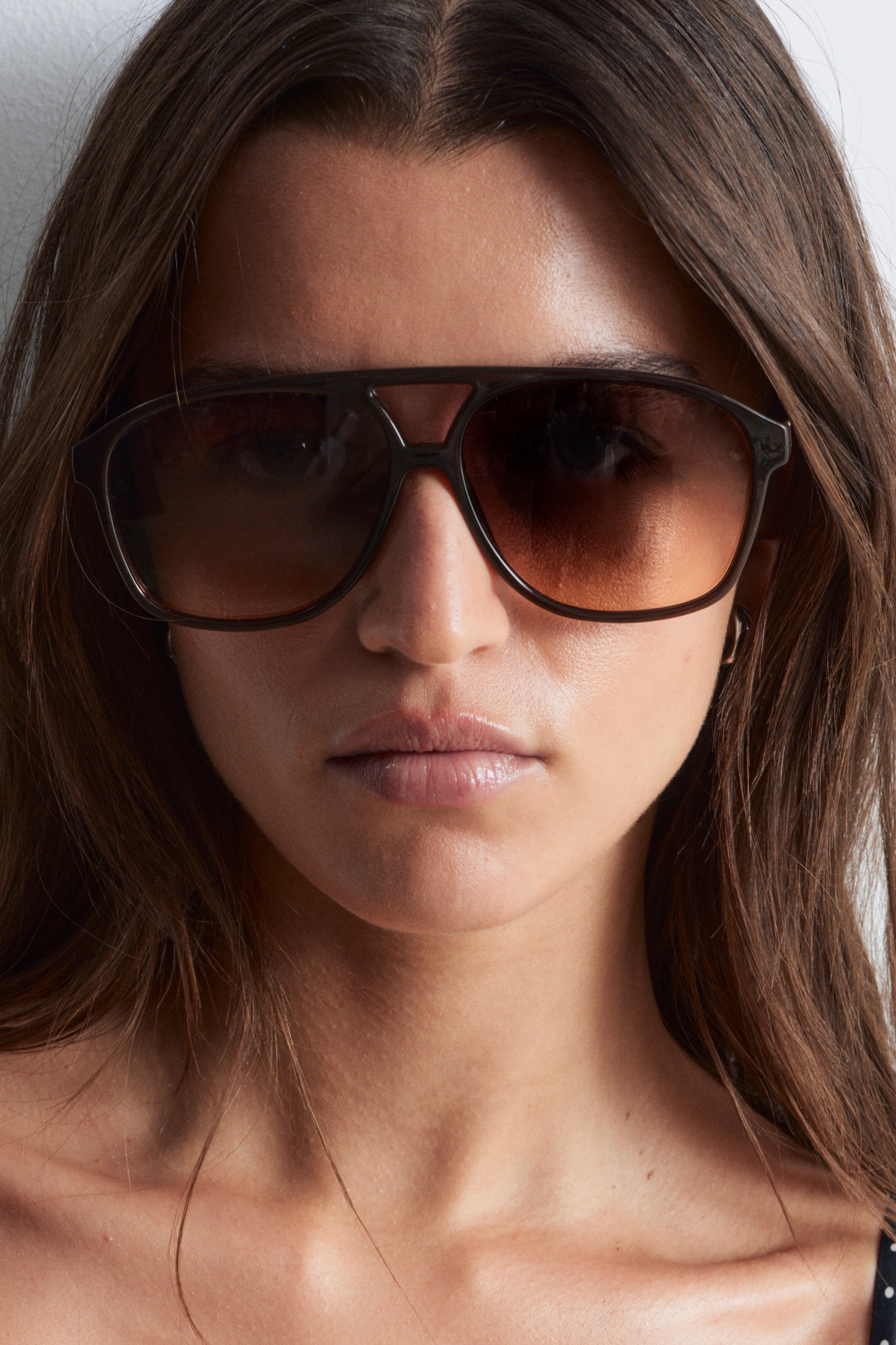 Größeres Bild ansehen: Übergroße Sonnenbrille im Aviator-Stil mit abgerundeten Kanten, einem klassischen Steg und dunklen Verlaufsgläsern wird vom Modell getragen.