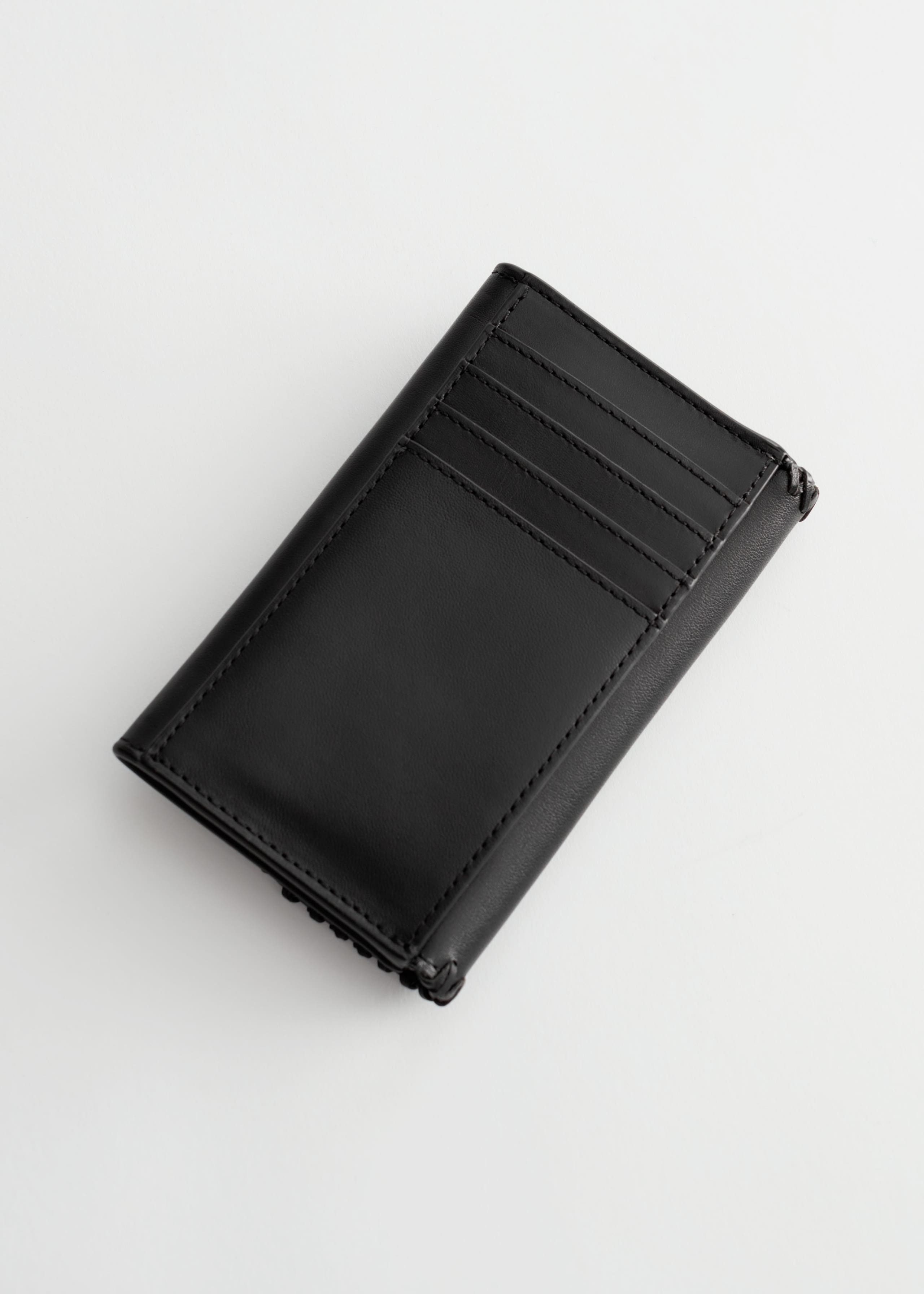 Geldbörse aus Leder mit geflochtener Schnalle - Schwarz - Stillleben