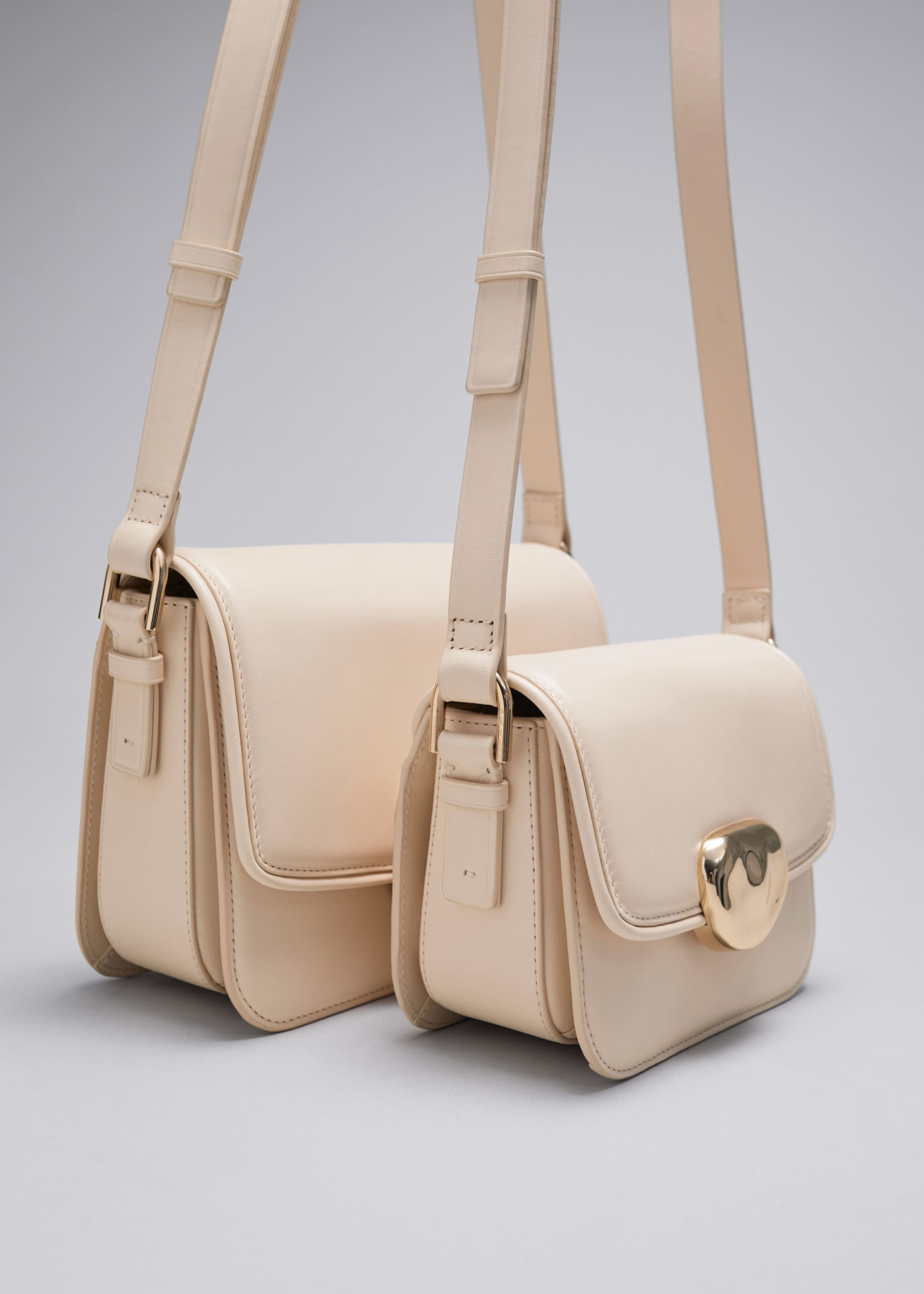 Kleine Ledertasche mit skulpturaler Schnalle - Creme - Stillleben