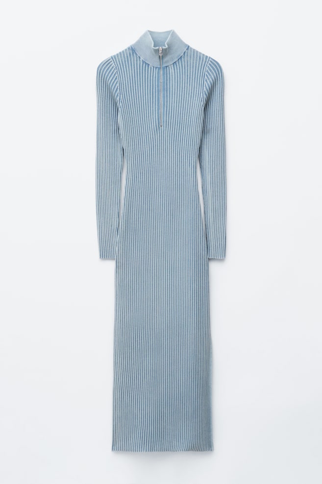 La robe est présentée de FACE, mettant en avant une robe maxi à manches longues, de couleur bleu clair avec des côtes verticales. Elle est conçue avec une silhouette ajustée et un col roulé zippé de couleur argentée. - 1