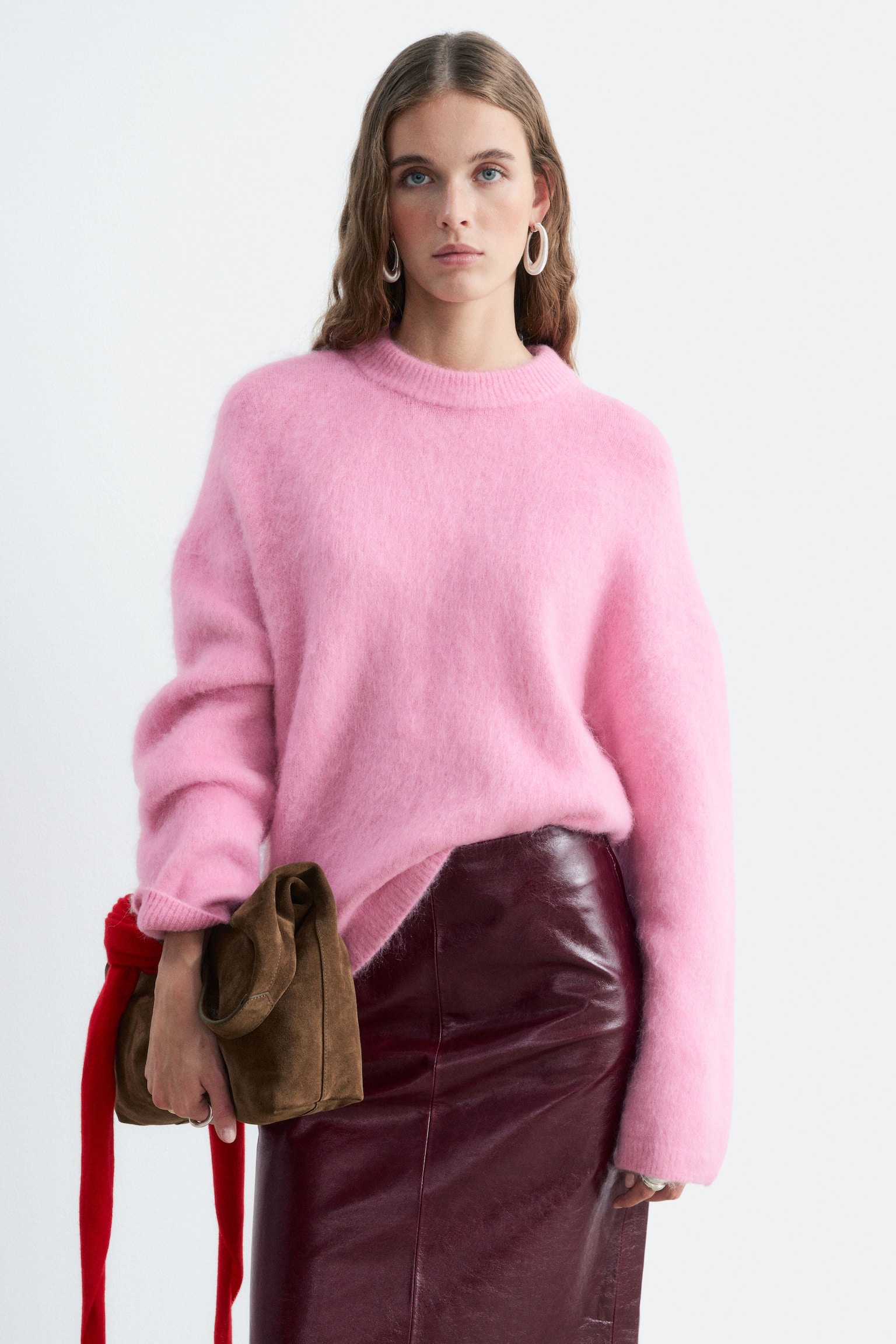 Un pull en mÃ©lange de mohair rose est prÃ©sentÃ© de face, mettant en valeur une texture duveteuse et une silhouette dÃ©contractÃ©e. Il prÃ©sente un col rond cÃ´telÃ©, des Ã©paules tombantes, ainsi que des poignets et un ourlet cÃ´telÃ©s. - 1