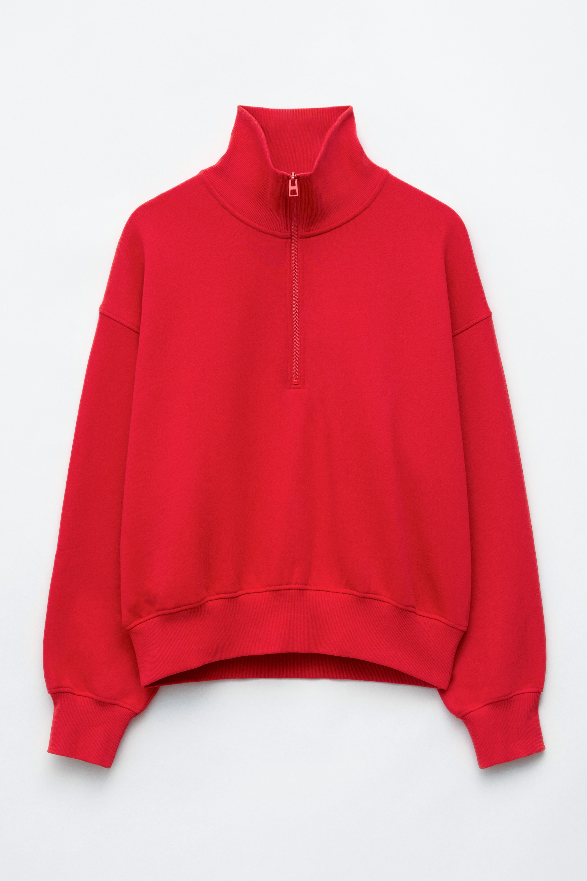 View larger image: A bright red, relaxed-fit sweatshirt is shown from the front, featuring a high collar with a half-zip fastening and dropped shoulders. The garment features ribbed knit trims on the collar, cuffs and hem.