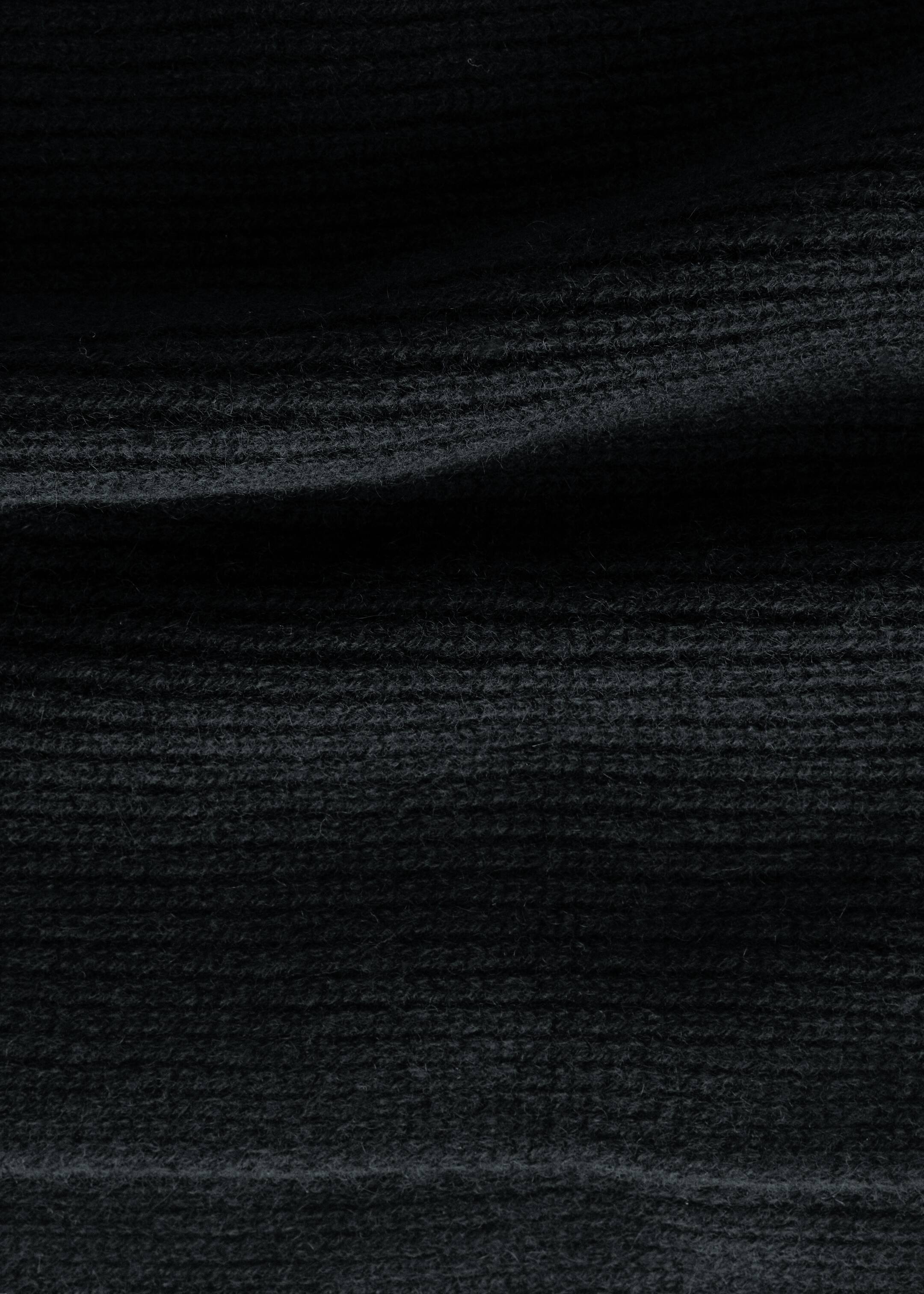 Größeres Bild anzeigen: Ein gestrickter Schal zeigt eine schwarze Farbe mit einer auffälligen Rippstruktur.