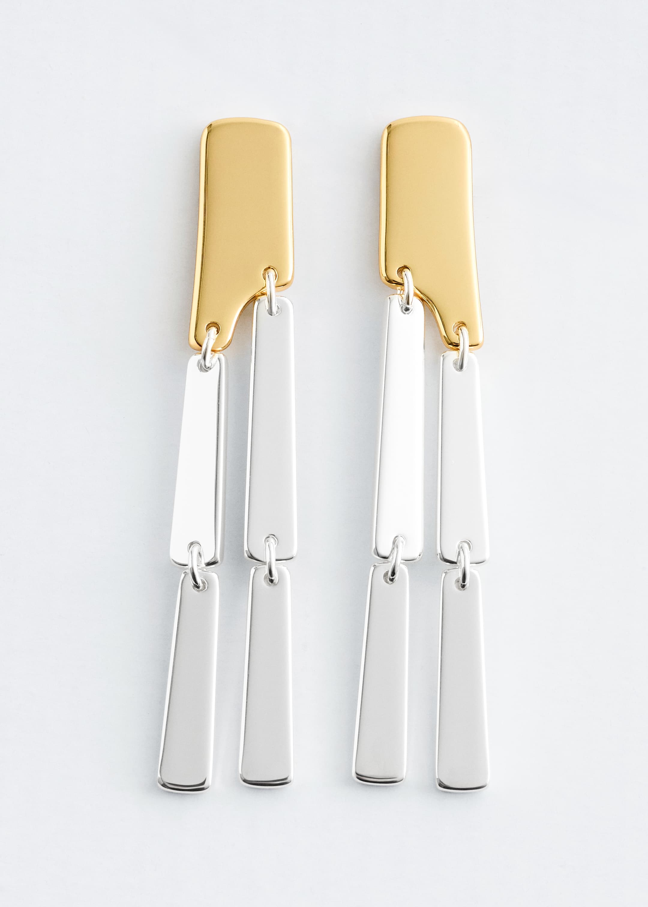 View larger image: A pair of Front-facing pendant earrings is showcasing a two-tone design, with each earring composed of a gold-tone top plate from which two silver-tone rectangular plates are dangling. An additional silver-tone plate is suspending from each of these two plates, forming a tiered cascade.