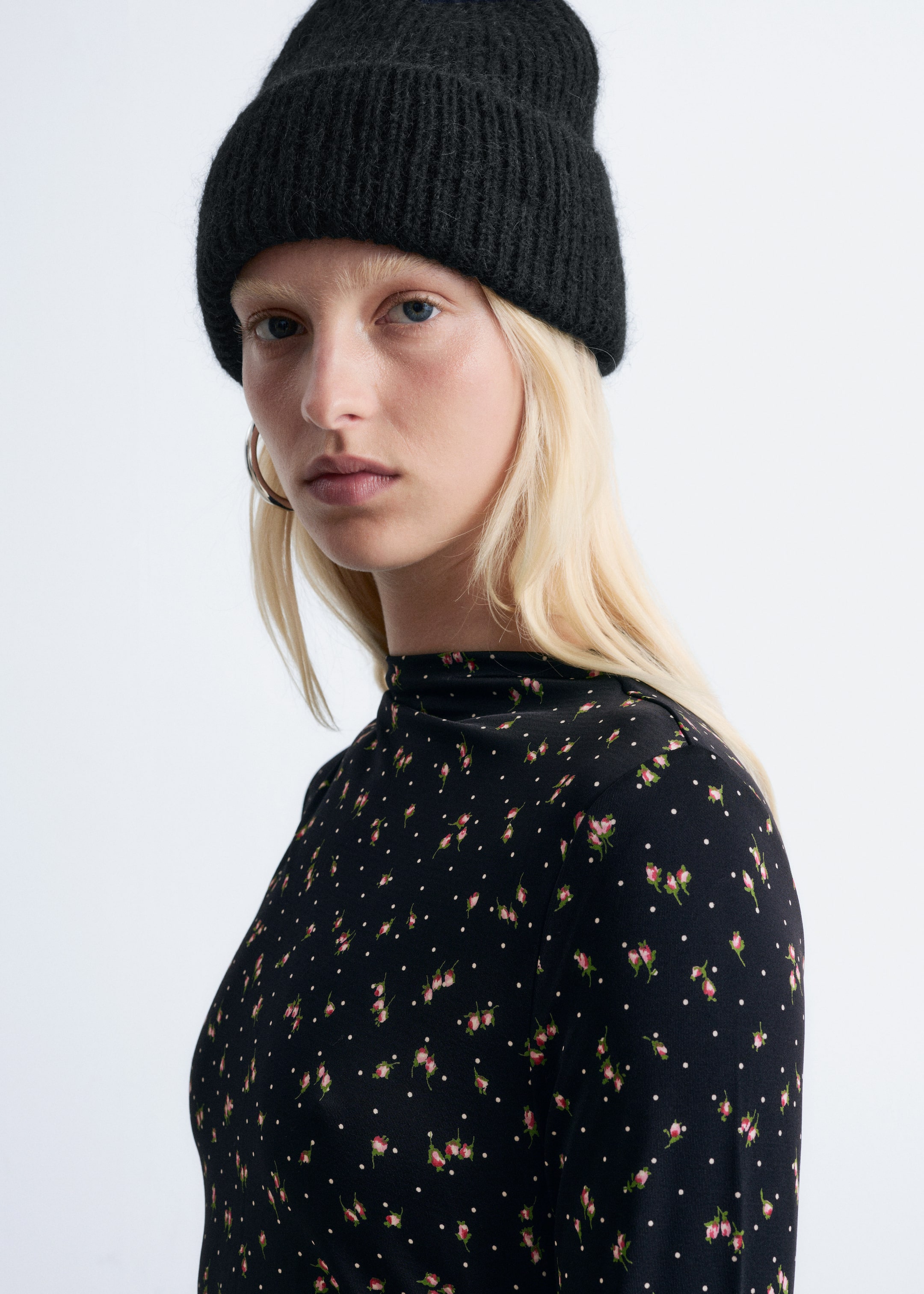 View larger image: A black knitted beanie is being worn, angled slightly to the left. It is featuring a ribbed folded cuff and a soft, fuzzy texture across its crown.