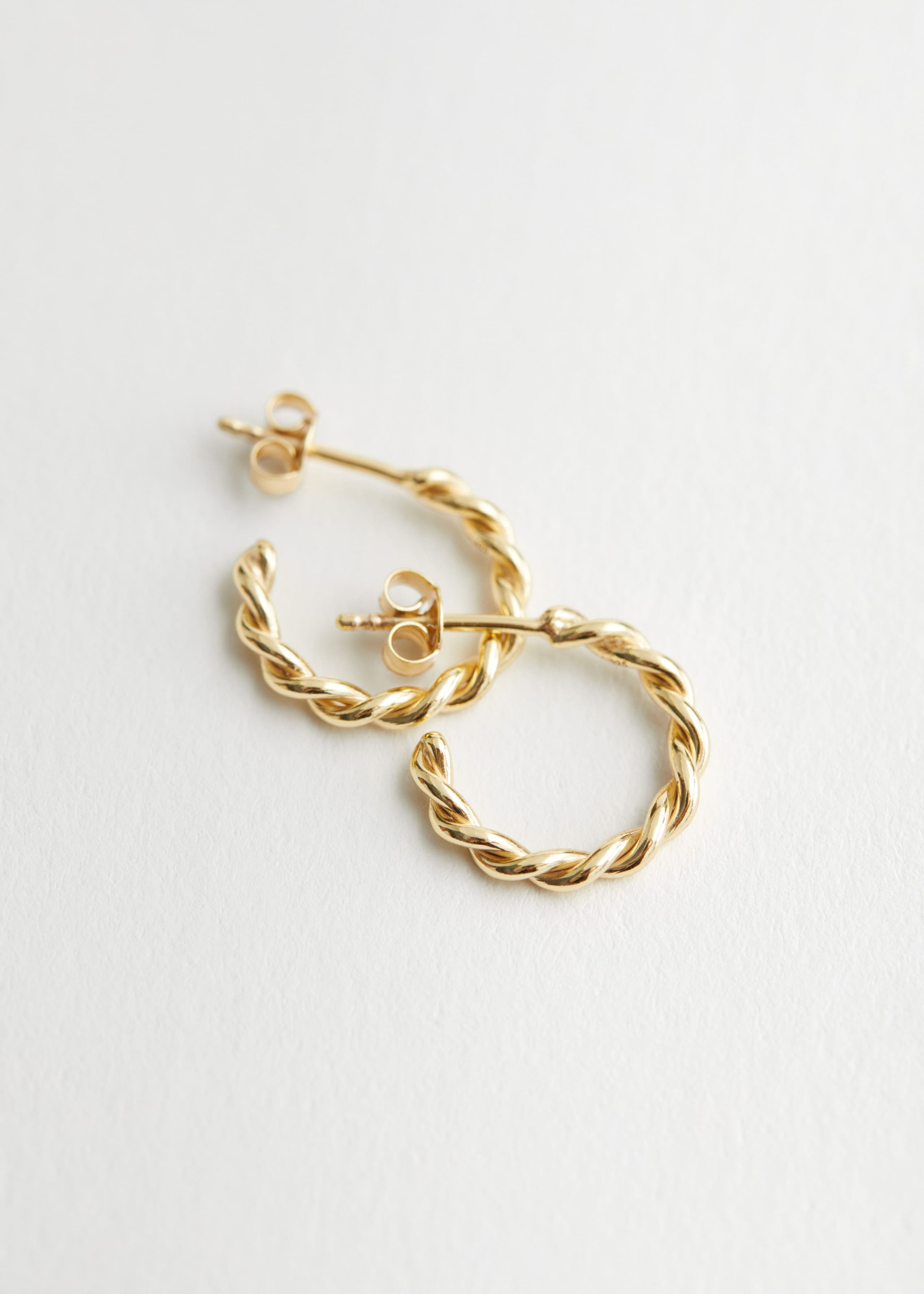 Sterling Silver Twisted Hoop Earrings - Gold - Natura morta
