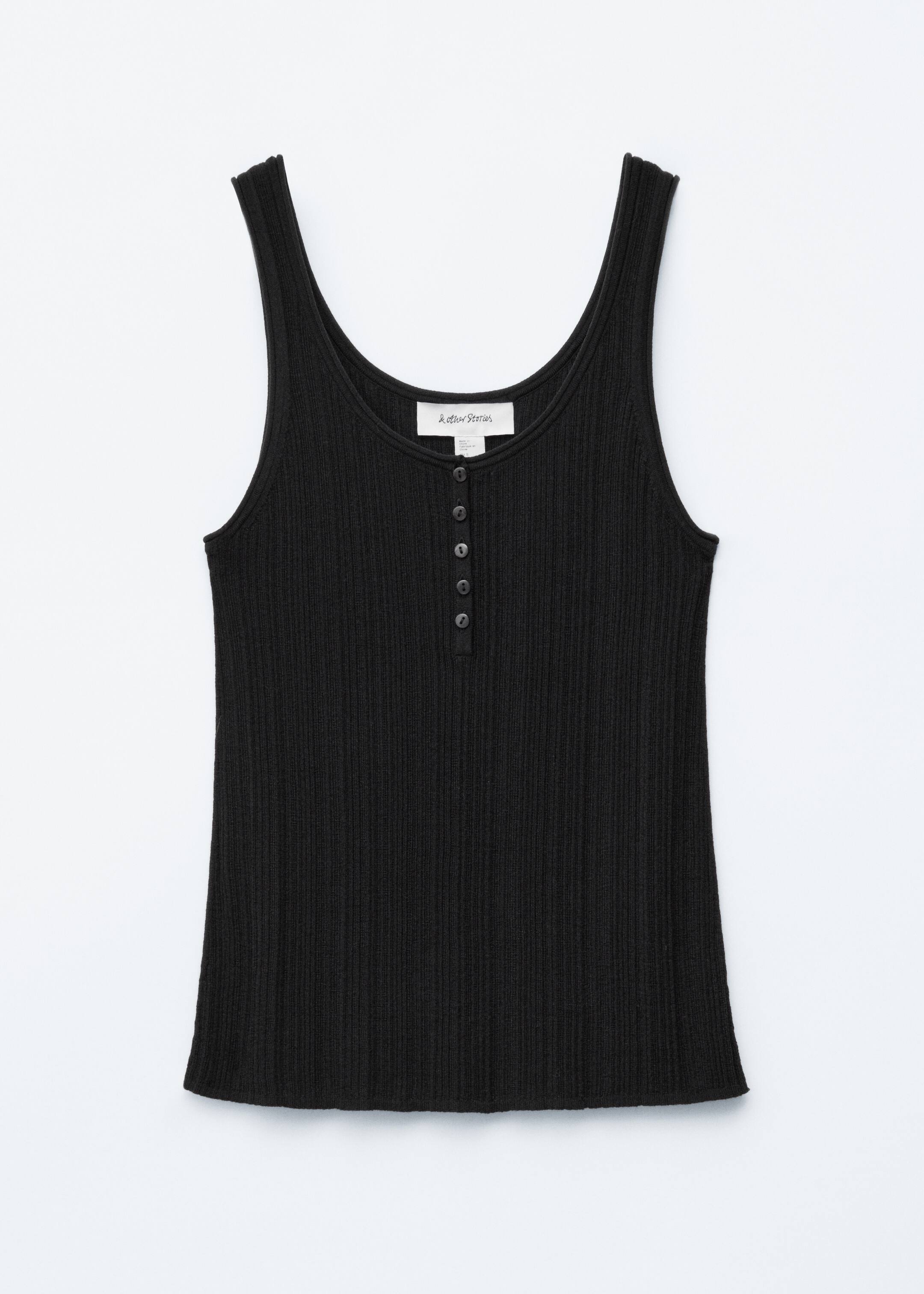 Se større billede: En sort tanktop præsenterer sin FRONT, med en ribbet strikstruktur. Den er designet med en rund halsudskæring og ærmegab, der har diskret rullede kanter, og en knappet halv stolpe fremhævet af fem mørke knapper på brystet.