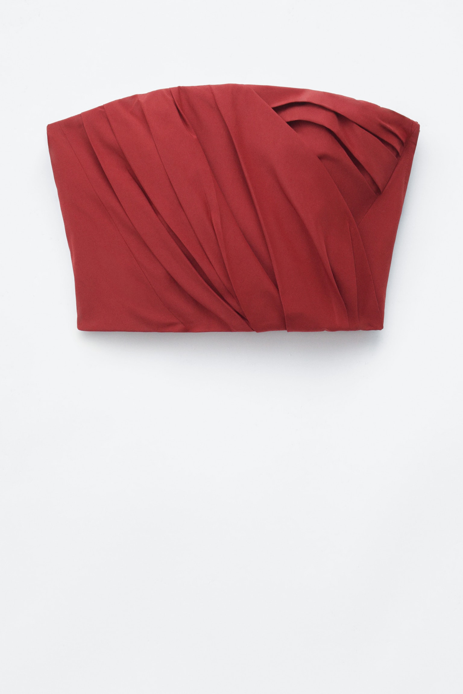 Top typu bustier bez ramienok v tmavo hrdzavo-Äervenej farbe mÃ¡ na prednom paneli skladanÃ©, prekrÃ½vajÃºce sa riasenie. Odev mÃ¡ mierne zahnutÃ½ vÃ½strih a rovnÃ½ spodnÃ½ lem a je prezentovanÃ½ naplocho spredu.