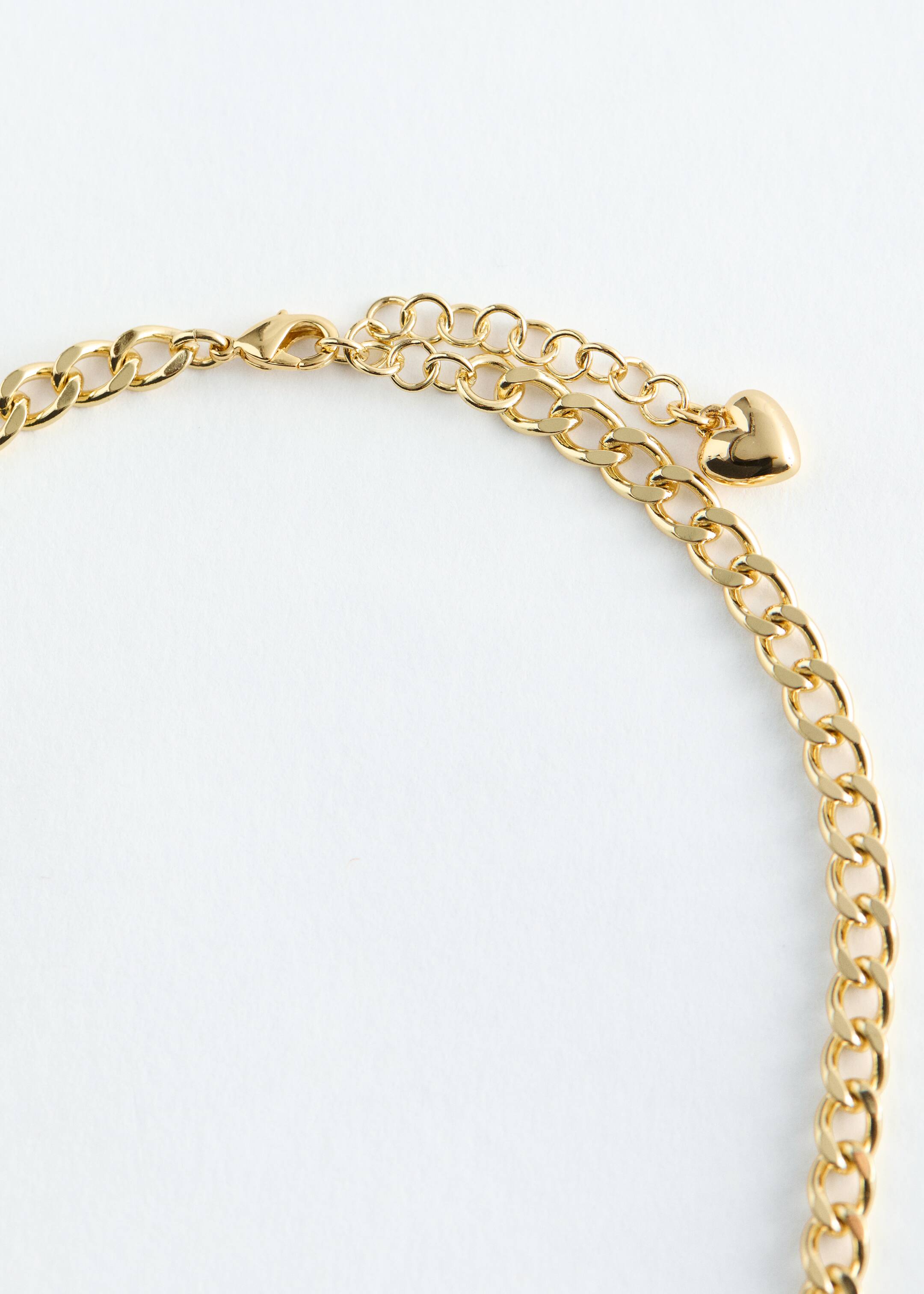 Agrandir l'image: Un collier court en laiton poli est doté d'un fermoir à déclenchement et d'une chaîne d'extension réglable, avec un petit pendentif en forme de cœur visible à l'extrémité de l'extension.