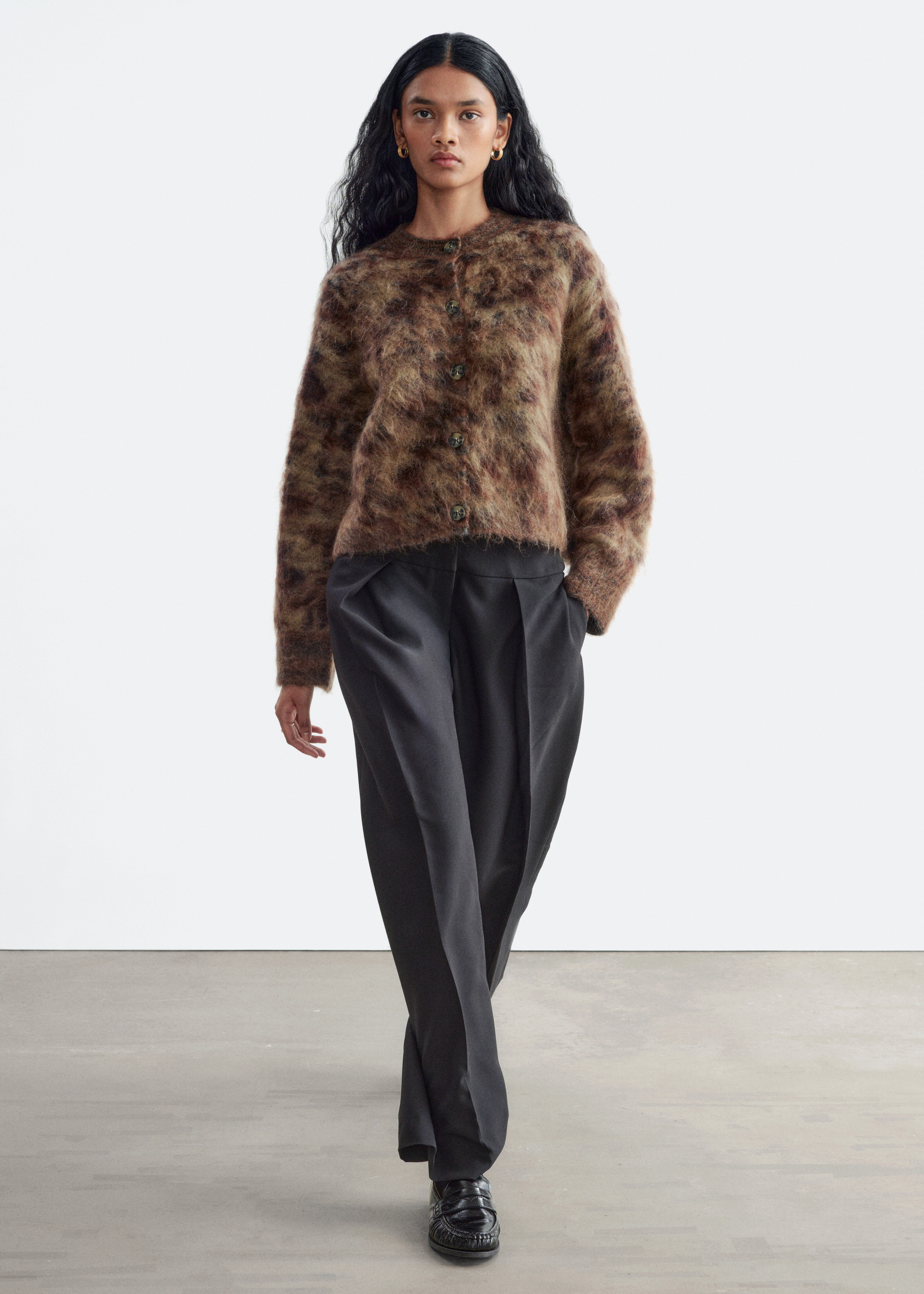 Ce cardigan en mÃ©lange de mohair est prÃ©sentÃ© de face, mettant en valeur son tricot duveteux et texturÃ© dans un motif mouchetÃ© brun et beige. Il prÃ©sente un col rond, une fermeture boutonnÃ©e sur le devant avec cinq boutons effet Ã©caille de tortue, ainsi que des manches longues.