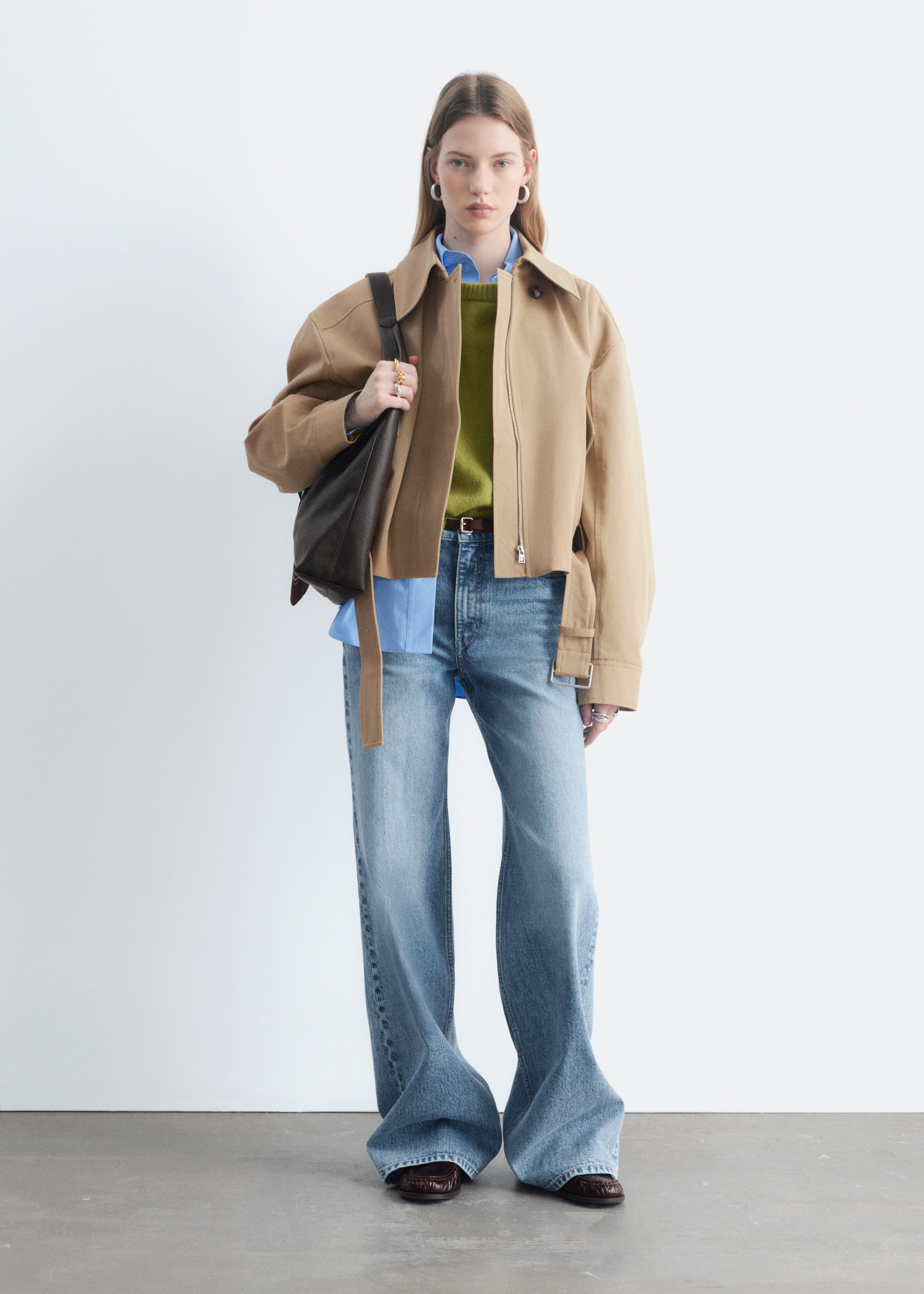 Ein Paar hellblaue Denim-Jeans präsentiert seine Vorderseite und zeichnet sich durch eine hohe Taille, einen Reißverschluss mit Knopfverschluss und ein klassisches 5-Taschen-Design mit langen, weiten Beinen und einer verwaschenen Optik aus.