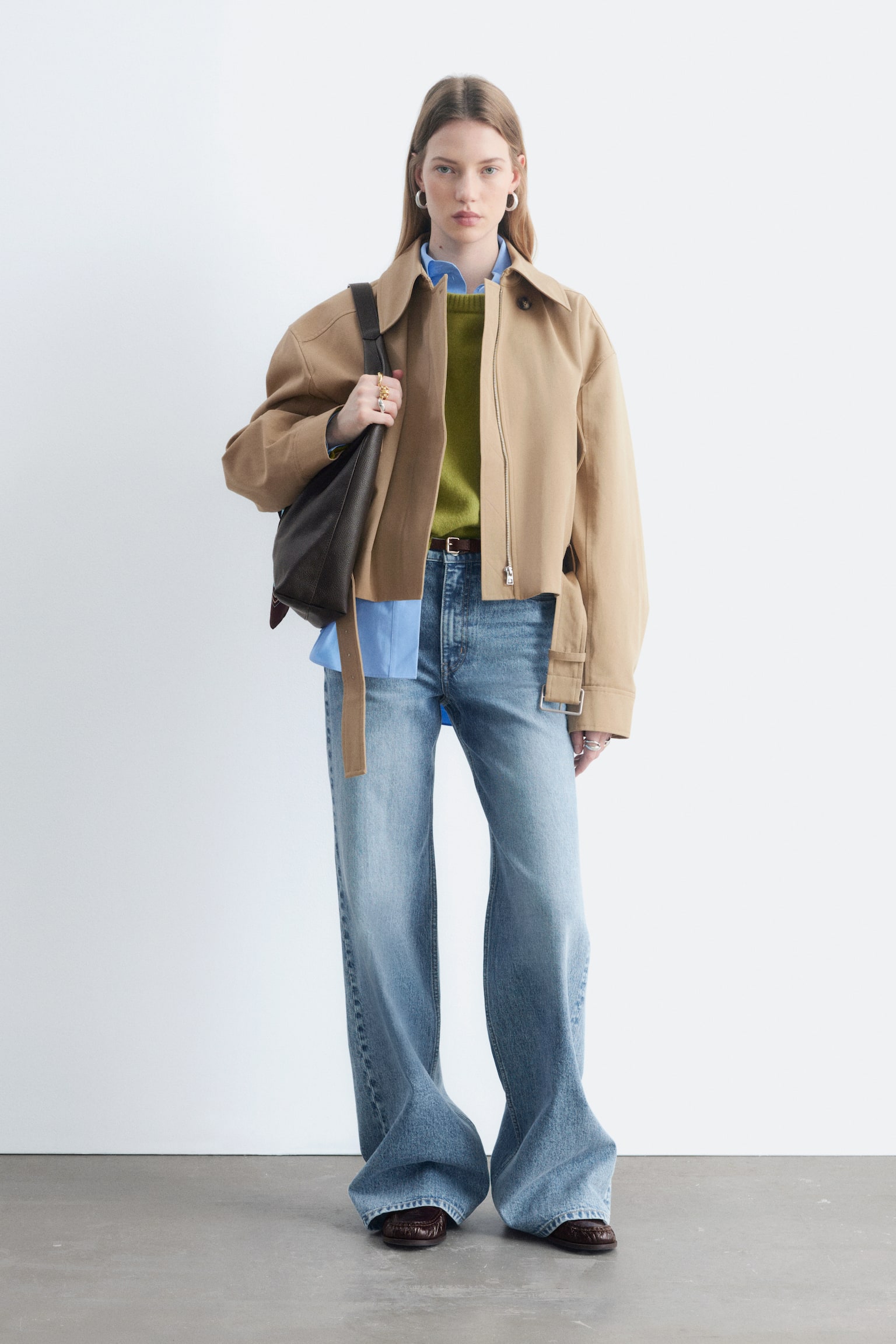Ein Paar hellblaue Denim-Jeans präsentiert seine Vorderseite und zeichnet sich durch eine hohe Taille, einen Reißverschluss mit Knopfverschluss und ein klassisches 5-Taschen-Design mit langen, weiten Beinen und einer verwaschenen Optik aus. - 1