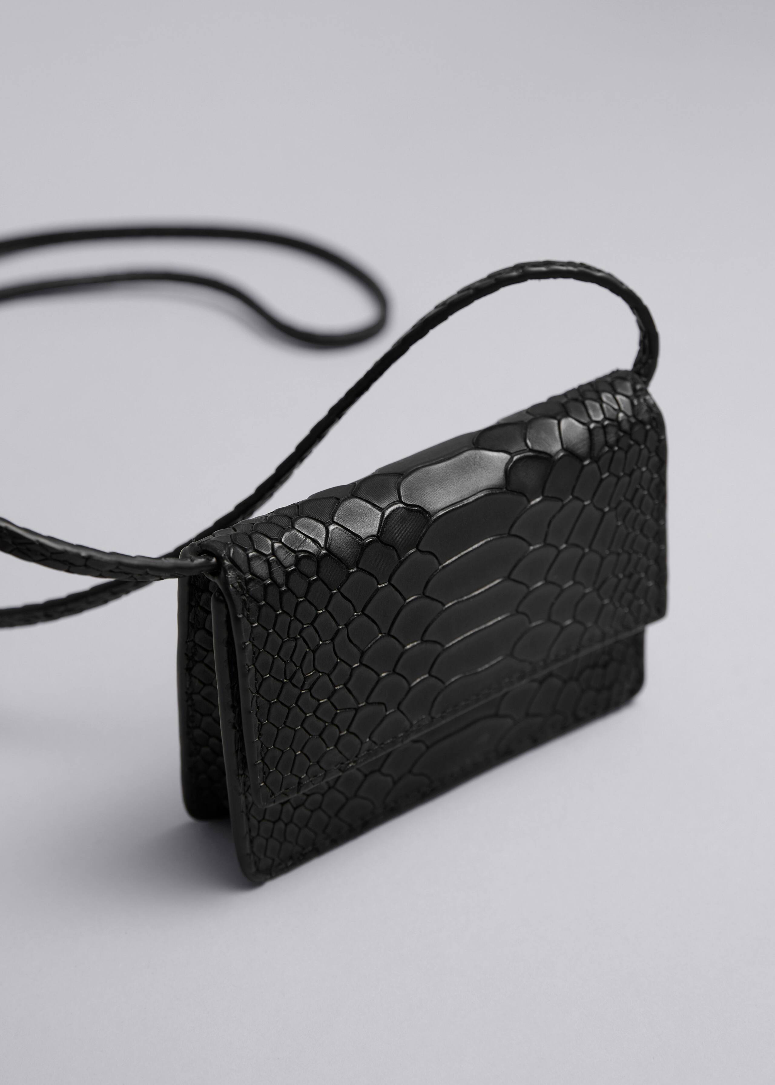 Minibolso de cuero - {{variantName}} - Detalle descriptivo