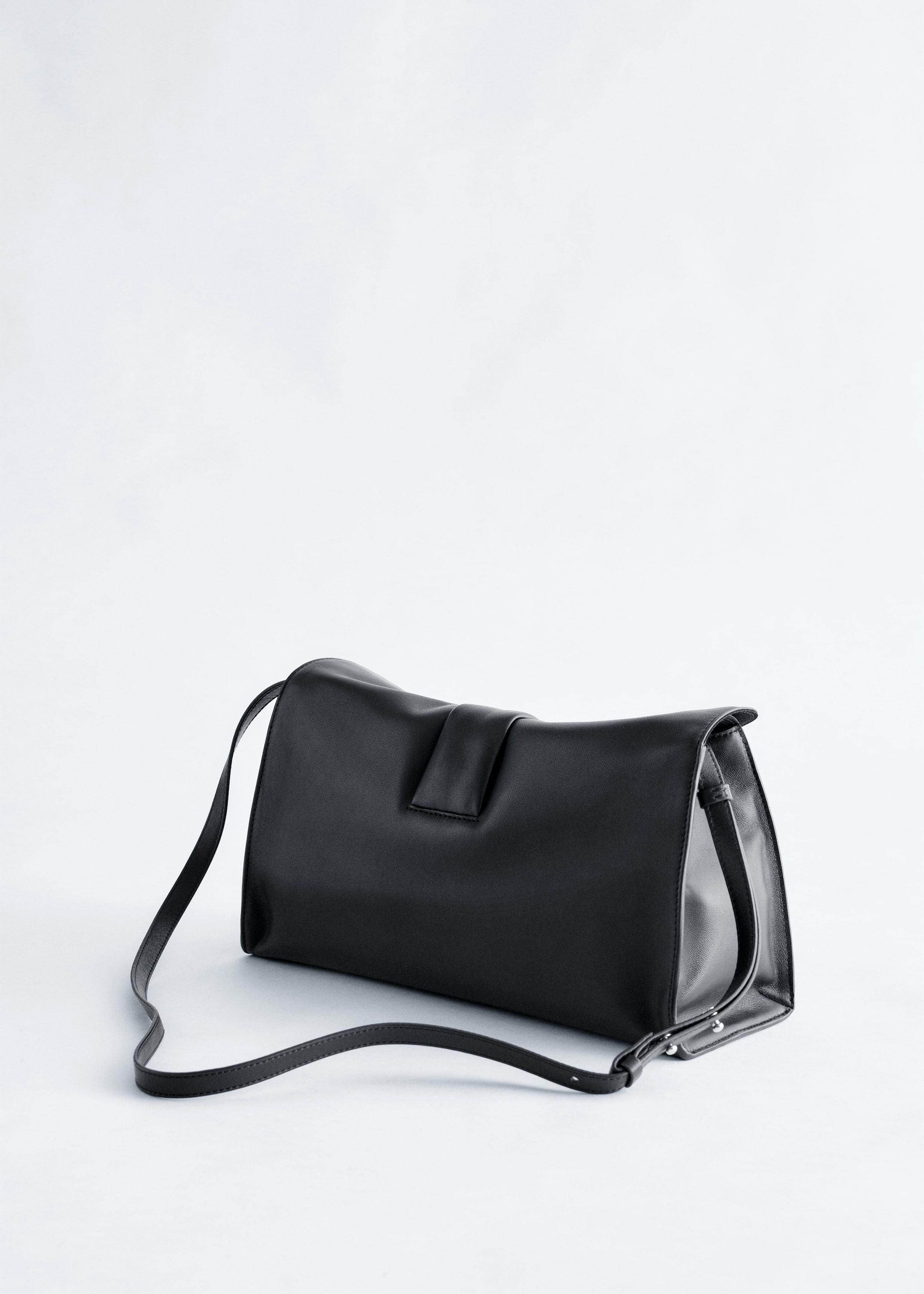 Größeres Bild ansehen: Eine schwarze, weiche, geschmeidige Leder-Clutch-Tasche verfügt über einen Frontklappenverschluss mit einem zusätzlichen Riegel und einem dünnen Schulterriemen, der von den Seiten ausgeht.