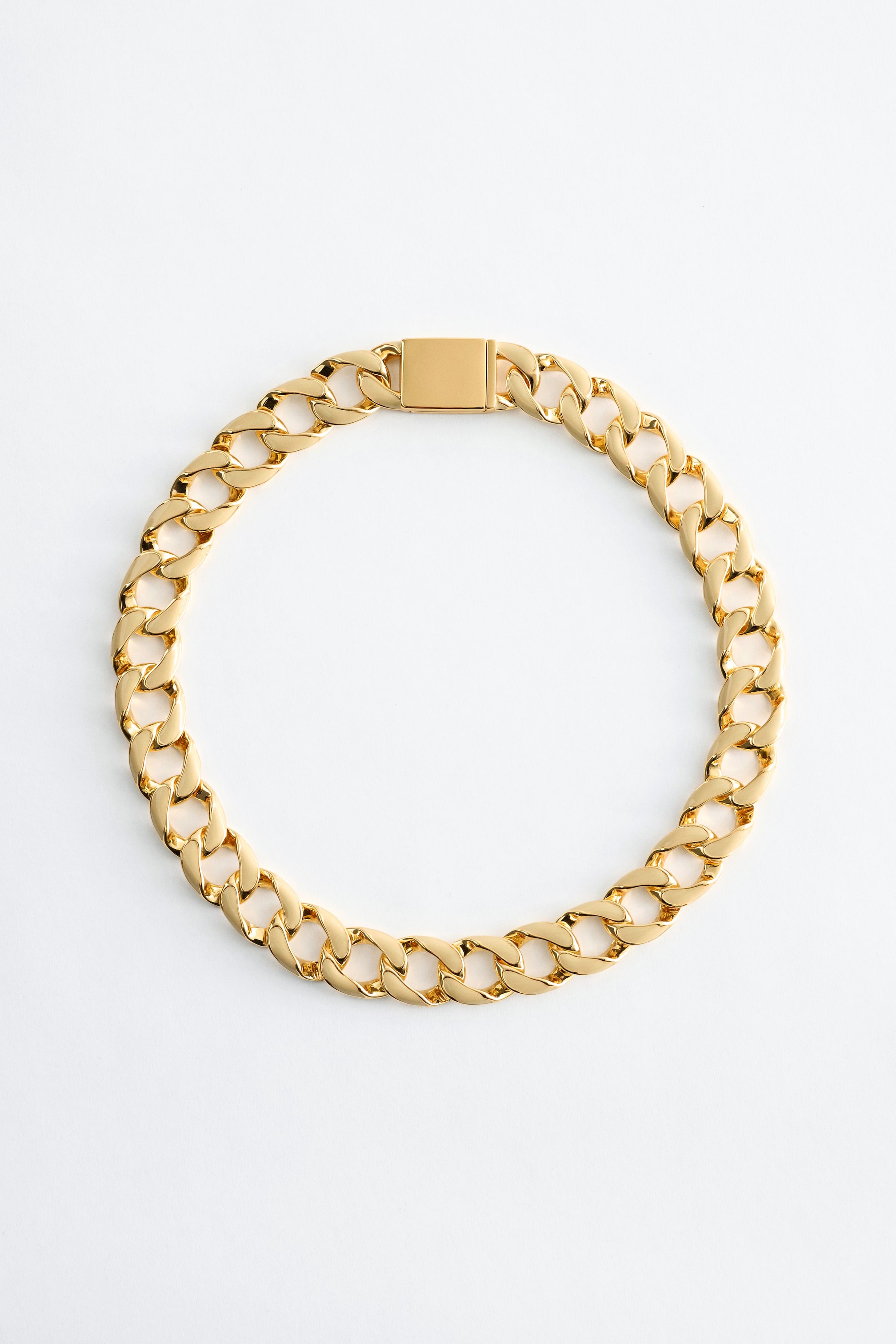 Grotere afbeelding bekijken: Een chunky curb-chain ketting vormt een cirkel, met gepolijste goudkleurige schakels en een rechthoekige sluiting.