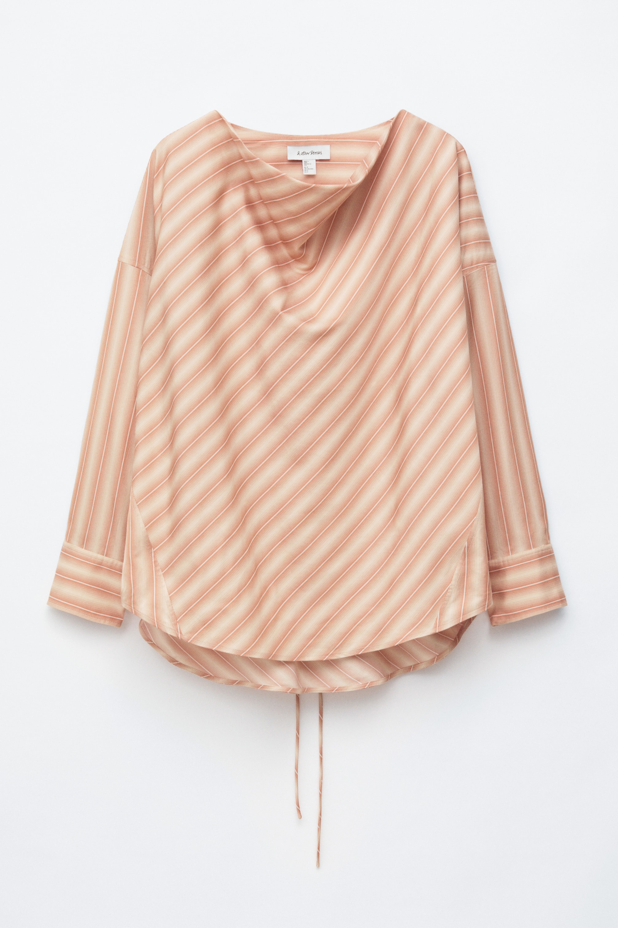 Agrandir l'image: Une blouse est présentée de face, avec un col bénitier et des rayures diagonales dans des tons de beige et de pêche. Elle est conçue avec des manches longues se terminant par des poignets boutonnés et un ourlet arrondi, duquel pendent deux fines attaches.