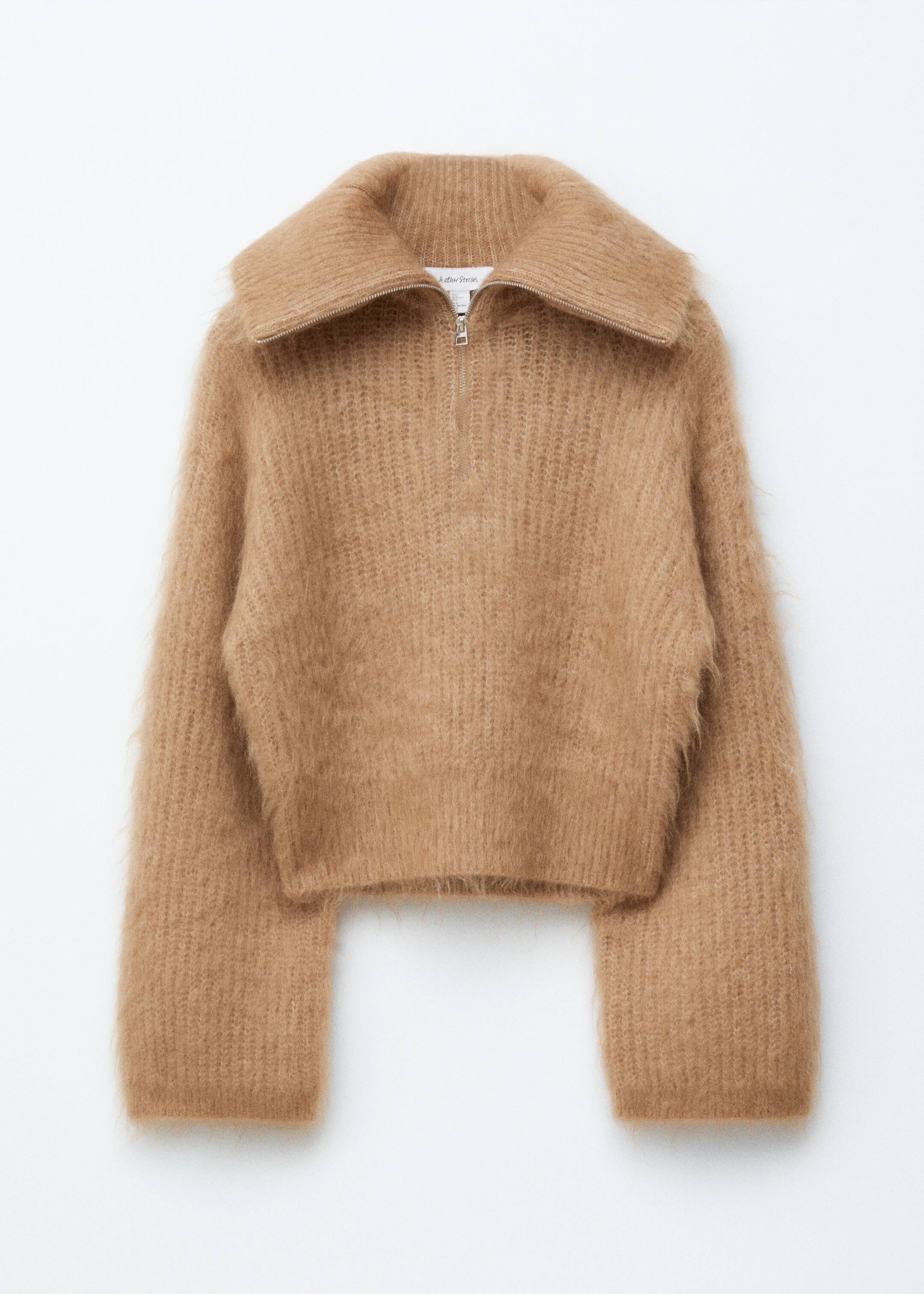 Grösseres Bild ansehen: Ein kamelfarbener, flauschiger Strickpullover ist nach vorne gerichtet und verfügt über einen breiten, umgeschlagenen Kragen und einen silberfarbenen Halbreißverschluss. Er ist mit langen, weiten Ärmeln und einem kurzen Saum gestaltet.