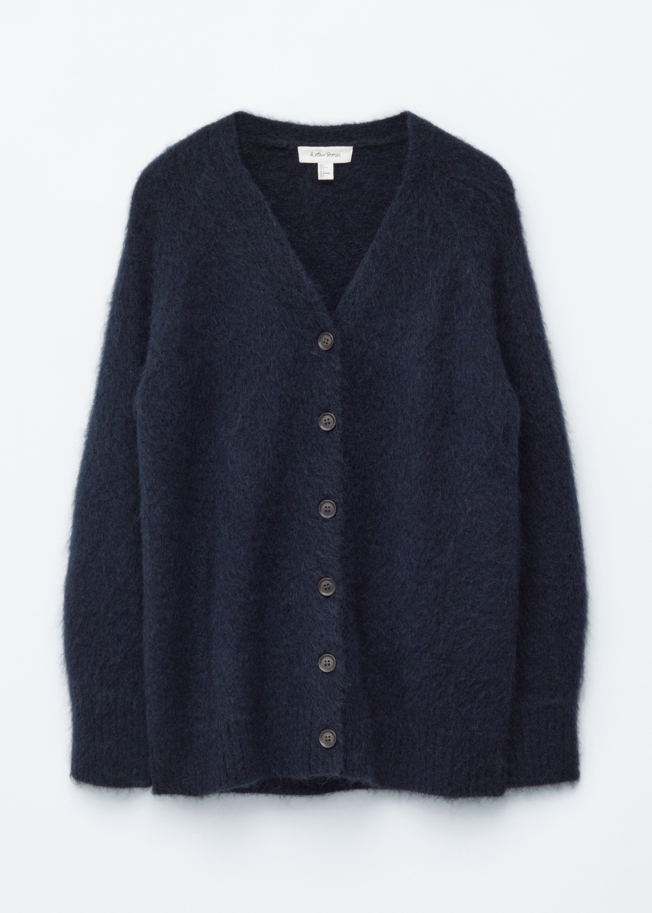 Agrandir l'image: Un cardigan en tricot duveteux bleu foncé est présenté de face, avec un col en V et six boutons circulaires foncés sur le devant.