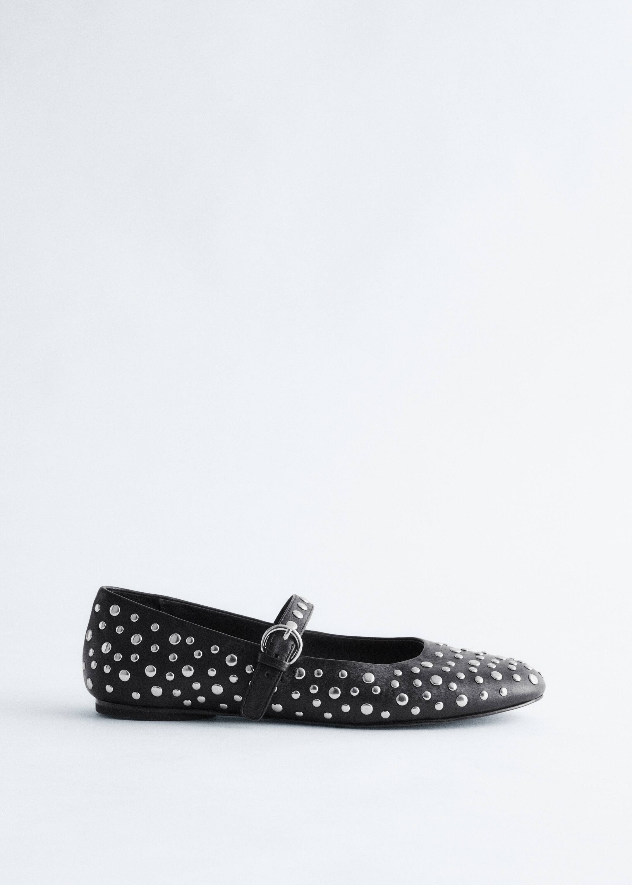 View larger image: A black Mary Jane ballet flat is facing left. The shoe is detailed with allover silver-toned metal studs and is featuring a single strap with a silver-toned buckle across the vamp.