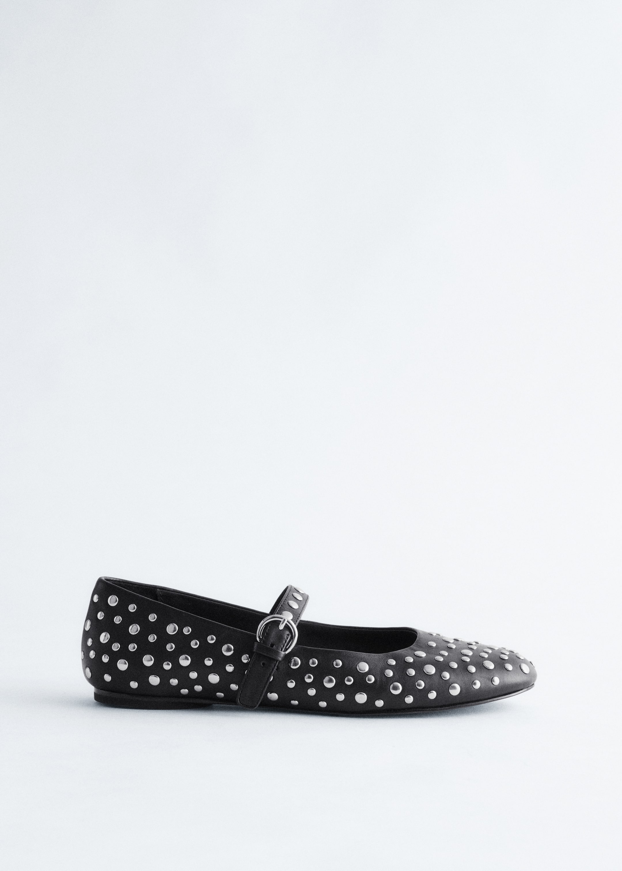 View larger image: A black Mary Jane ballet flat is facing left. The shoe is detailed with allover silver-toned metal studs and is featuring a single strap with a silver-toned buckle across the vamp.