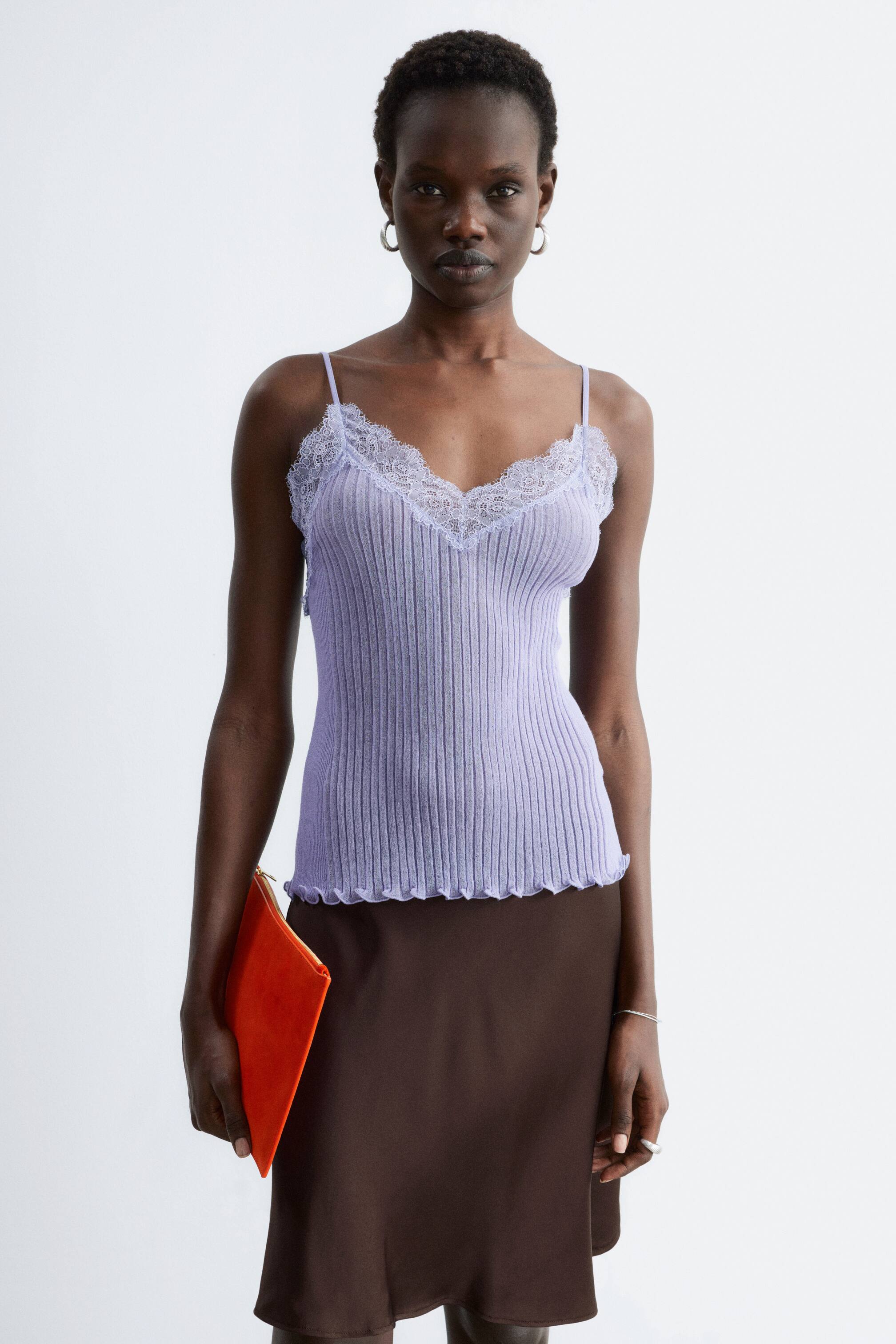 Se større billede: En tætsiddende lyse lilla ribstrikket camisole med V-udskæring og hvid blondekant, tynde spaghetti-stropper og en bølget salatkant.