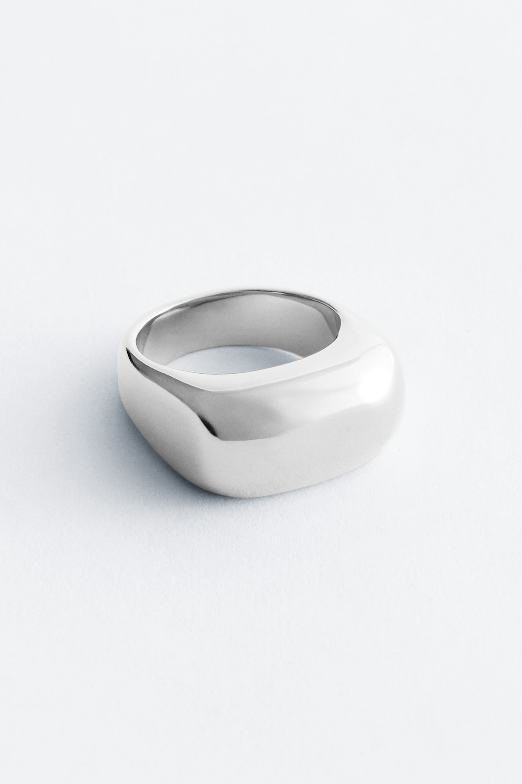 Grösseres Bild ansehen: Der Ring ist ein klobiger, silberfarbener Band, der eine organische, abgerundete und leicht unregelmässige Form mit einer glatten, polierten Oberfläche aufweist.