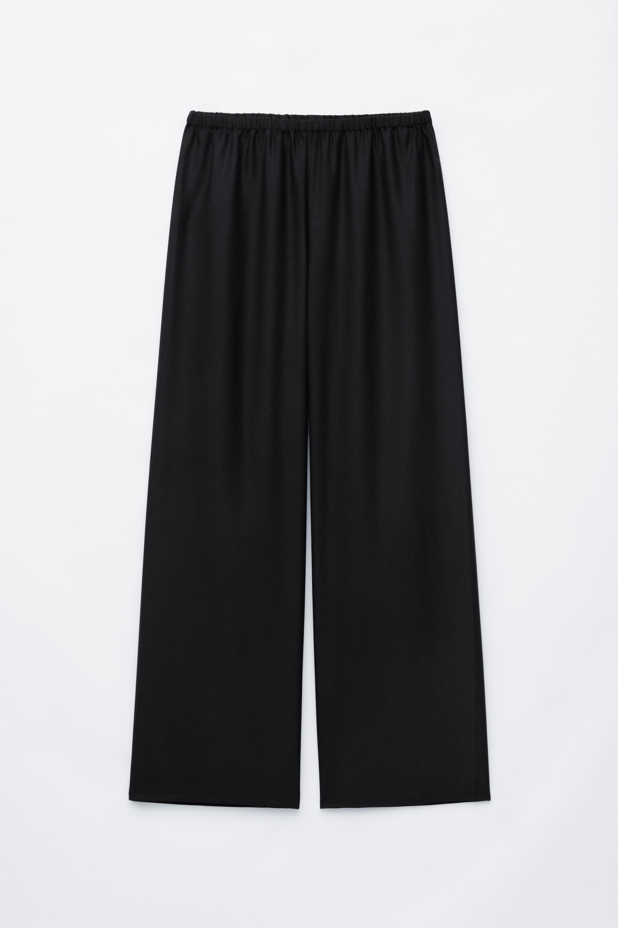 Visualizza l'immagine ingrandita: Pantaloni pull-on neri in lana, appesi piatti frontalmente, con vita elasticizzata arricciata e una silhouette rilassata a gamba larga. I pantaloni cadono dritti fino a un orlo pulito, mettendo in risalto il loro design senza cuciture.