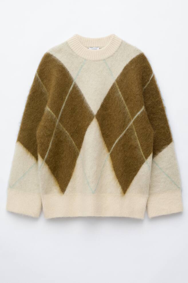 Un pull en mÃ©lange de mohair est prÃ©sentÃ© de face, avec une texture duveteuse et un grand motif argyle marron et crÃ¨me. La maille oversize prÃ©sente un col rond cÃ´telÃ©, des Ã©paules tombantes et de larges finitions cÃ´telÃ©es aux poignets et Ã  lâourlet. - 1