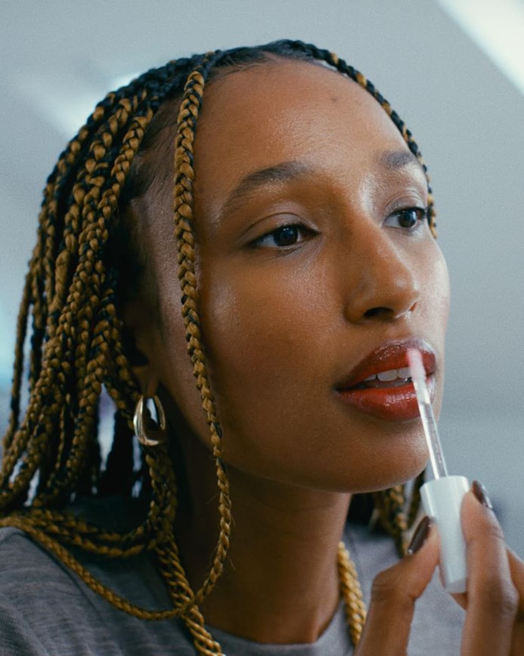 Woman putting on lipgloss